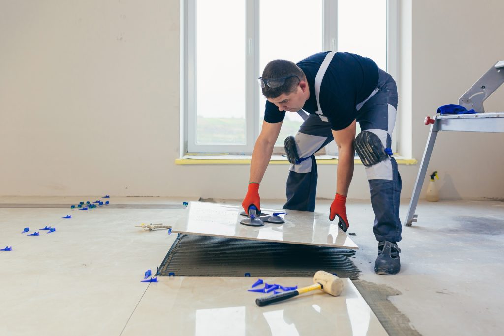A,Male,Construction,Worker,Installs,A,Large,Ceramic,Tile